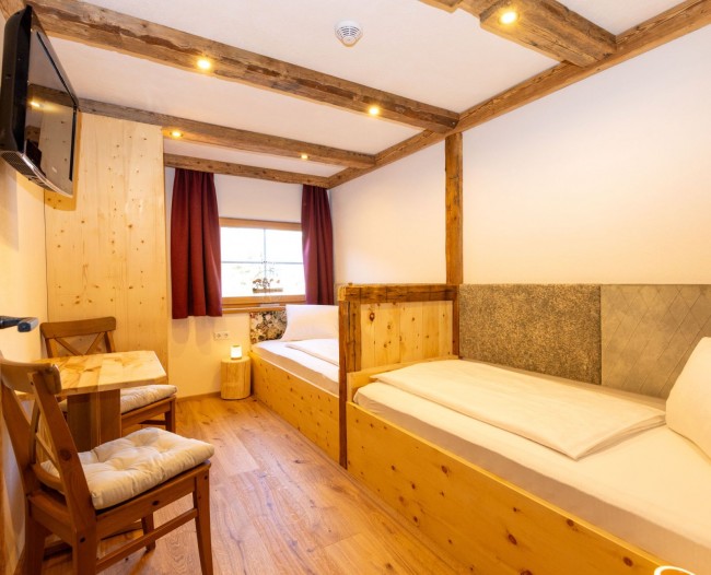 Kinderzimmer aus Zirbenholz mit hintereinander gereihten Betten